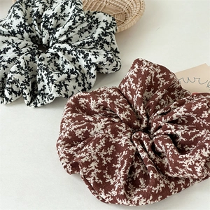 Detailed view of floral fabric scrunchies with elegant pleats and textile texture