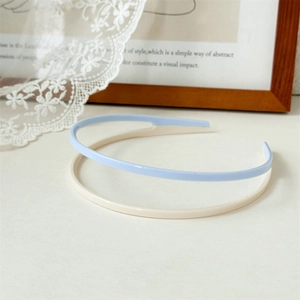 Close-up of light blue and cream acrylic headbands with non-slip inner teeth detail