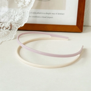 Close-up of dual-layer acrylic headbands in cream and purple with anti-slip teeth