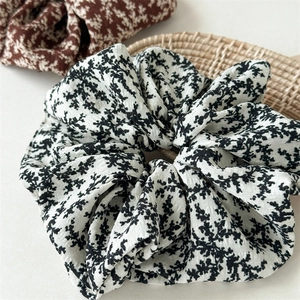 Detailed close-up of floral fabric scrunchies with elegant black and brown patterns