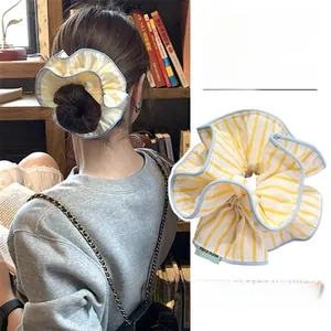 Detail of yellow and blue striped scrunchie with handmade tag and double-layer design