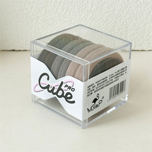 Détail de 6 élastiques à cheveux café dans une boîte de rangement cubique