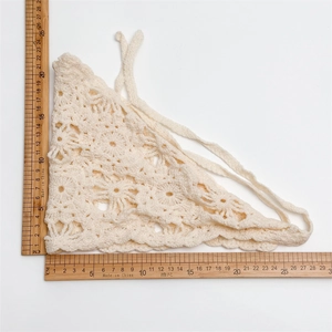 Detailed macro view of cream crochet triangle kerchief with hollow floral knitting pattern