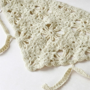 Close-up of beige crochet floral headscarf showing detailed hollow knit patterns