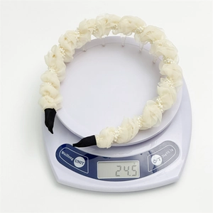Close-up of pleated mesh headband with pearls showing a light weight of 24.5g on scale