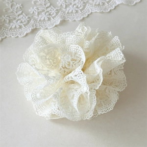 Détail d'un chouchou en dentelle blanc crème à double couche avec volants délicats