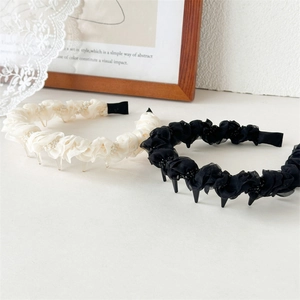 Detail showing sheer pleated mesh texture and delicate bead accents on hairbands