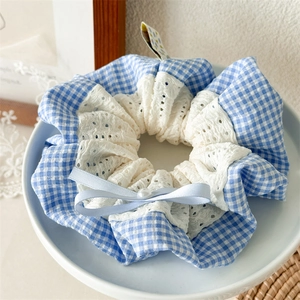 Detail of blue plaid fabric hair scrunchie with lace trim, silk bow and pearl accent