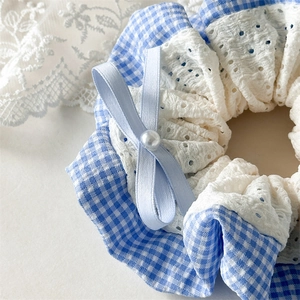 Close-up of blue gingham hair scrunchie with lace trim and pearl bow detail