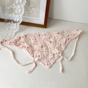 Close-up of pink crochet triangle headscarf featuring hollow floral knit patterns and ties