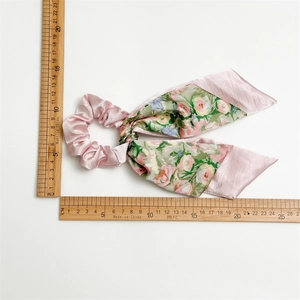 Pink satin and floral print ponytail scrunchie with long ribbons shown with measurement