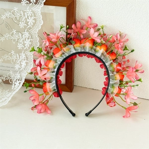 Dettaglio del cerchietto con fiori rosa e pizzo bianco su un tavolo decorativo