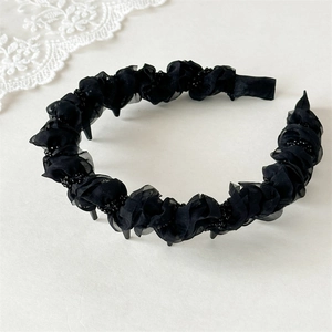 Close-up of black mesh pleated headband with bead accents and non-slip inner teeth