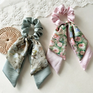 Detail shot of sage green and pink floral satin scrunchies with long ribbon tails