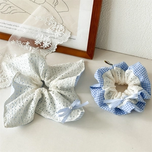 Detail of blue plaid and white lace scrunchies with bow ribbons and faux pearl beads