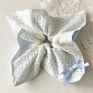 Detail of blue lace scrunchie with polka dots, soft embroidery and pearl bow accent