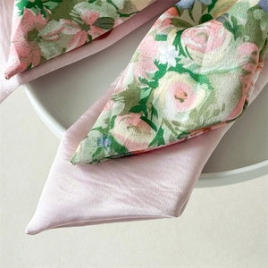 Detail of floral pattern and pink satin fabric on a handmade double-layer hair scrunchie
