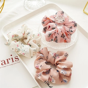 Three-piece set of floral chiffon scrunchies in cream, pink, and mauve for ponytails