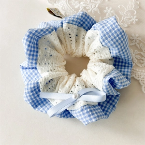 Detailed view of blue checkered scrunchie with lace bow and pearl center ornament