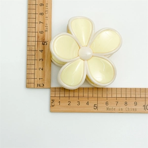 Pince à cheveux fleur jaune pâle en acrylique avec mesure de 7,5 cm sur fond blanc