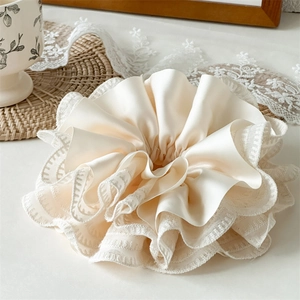 Detailed macro shot of premium off-white satin hair scrunchie with lace edges and ruffles