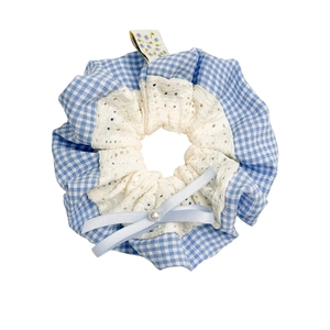Blue plaid scrunchie with white lace trim, satin bow and pearl detail on white background