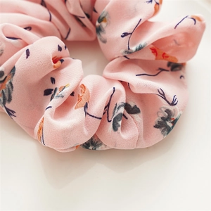 Macro detail of pink chiffon floral scrunchie with blue and orange prints for women