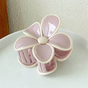 Vue détaillée de la pince à cheveux en forme de fleur bicolore rose et blanc crème