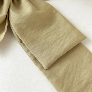 Macro shot of olive green fabric texture showing fine weave on a French bow hair accessory