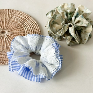 Detailed shot of striped lace and floral scrunchies on a natural woven mat