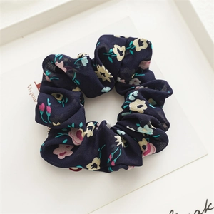 Detailed view of dark blue floral chiffon scrunchie showing fabric texture and print