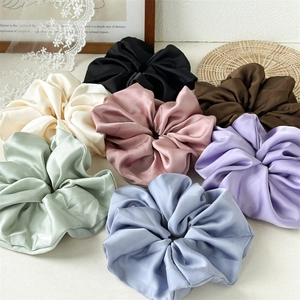 Detailed close-up showing silk satin fabric texture and multi-color scrunchie variety