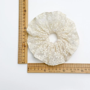 Chouchou en dentelle blanche brodée avec motif floral et texture en tulle transparent