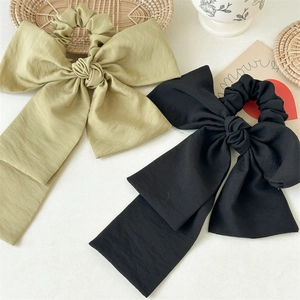 Flat lay of olive green and black large linen bow hair ties with long streamers