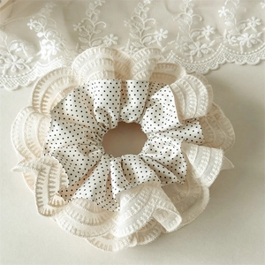 Close-up of double-layered hair scrunchie with polka dots and vintage lace edges