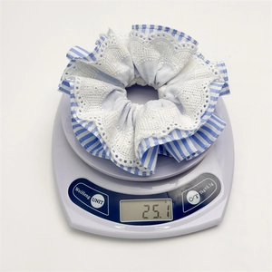 Blue striped multi-layered pleated scrunchie with lace trim on a scale for 25g weight