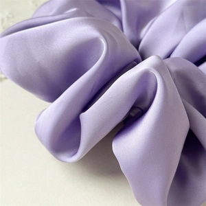 Close-up of premium lavender satin hair scrunchie with elegant silky texture and soft sheen