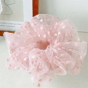 Detailed shot of pink mesh hair scrunchie with 3D velvet hearts and soft texture