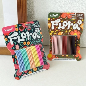 Detail showing two packs of colorful seamless elastic hair ties on floral cards