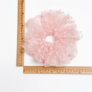 Detailed view of oversized pink tulle scrunchie with heart patterns measuring 18cm to 20cm