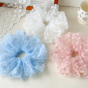 Detailed view of oversized mesh scrunchies with heart patterns in pastel colors