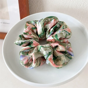 Detailansicht eines großen Blumen Haargummis aus Seide mit elegantem Band im Vintage Stil