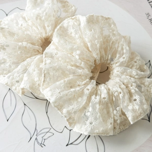 Gros plan de chouchous en dentelle blanche avec broderie florale et style français vintage