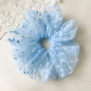 Close-up of light blue mesh hair scrunchie with sweet heart patterns for hair styling