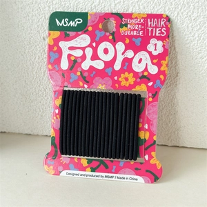 Macro detail of 20 high-elastic seamless black hair ties on a floral Flora display card