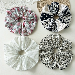 Floral and striped fabric hair scrunchies set on lace and straw mat background