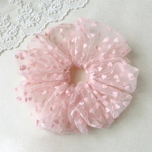 Detailed shot of light pink mesh scrunchie featuring cute velvet heart patterns