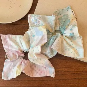 Pastel floral scrunchie with patchwork print on a rustic wooden tabletop