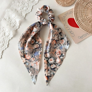 Blumenmuster Haargummi mit langen Bändern aus rosa Chiffon auf minimalistischem Hintergrund