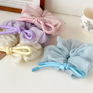 Close-up of elegant organza scrunchies in pastel pink, lilac, beige and light blue